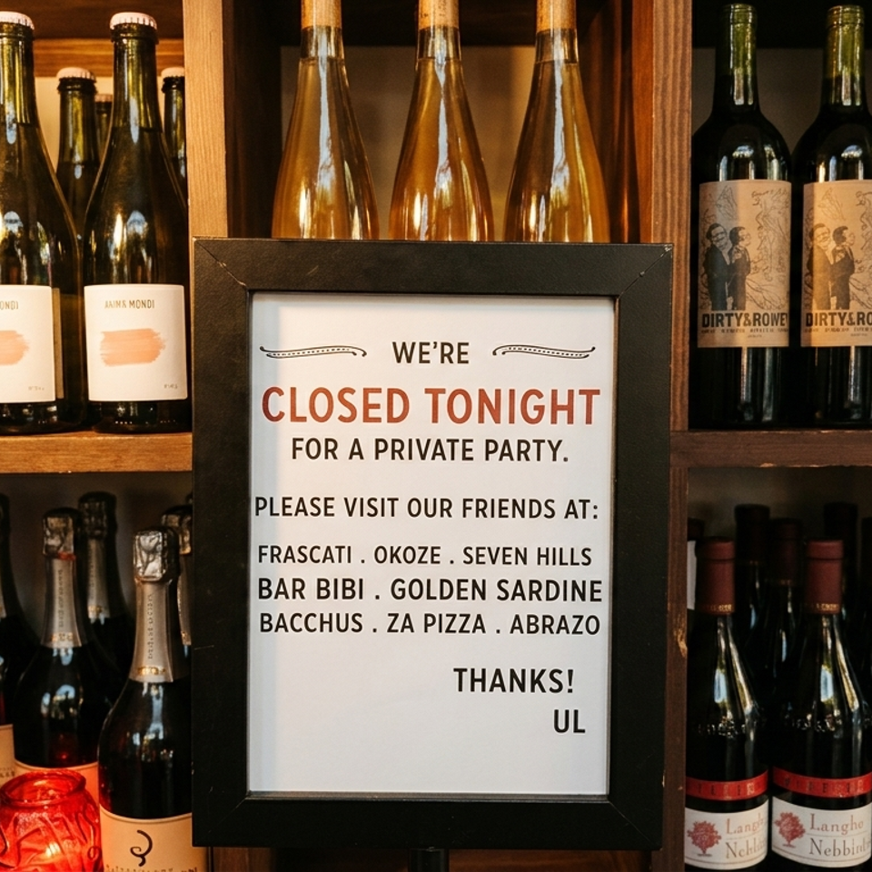 A "Closed Tonight" sign stands amidst shelves filled with various wine and champagne bottles.